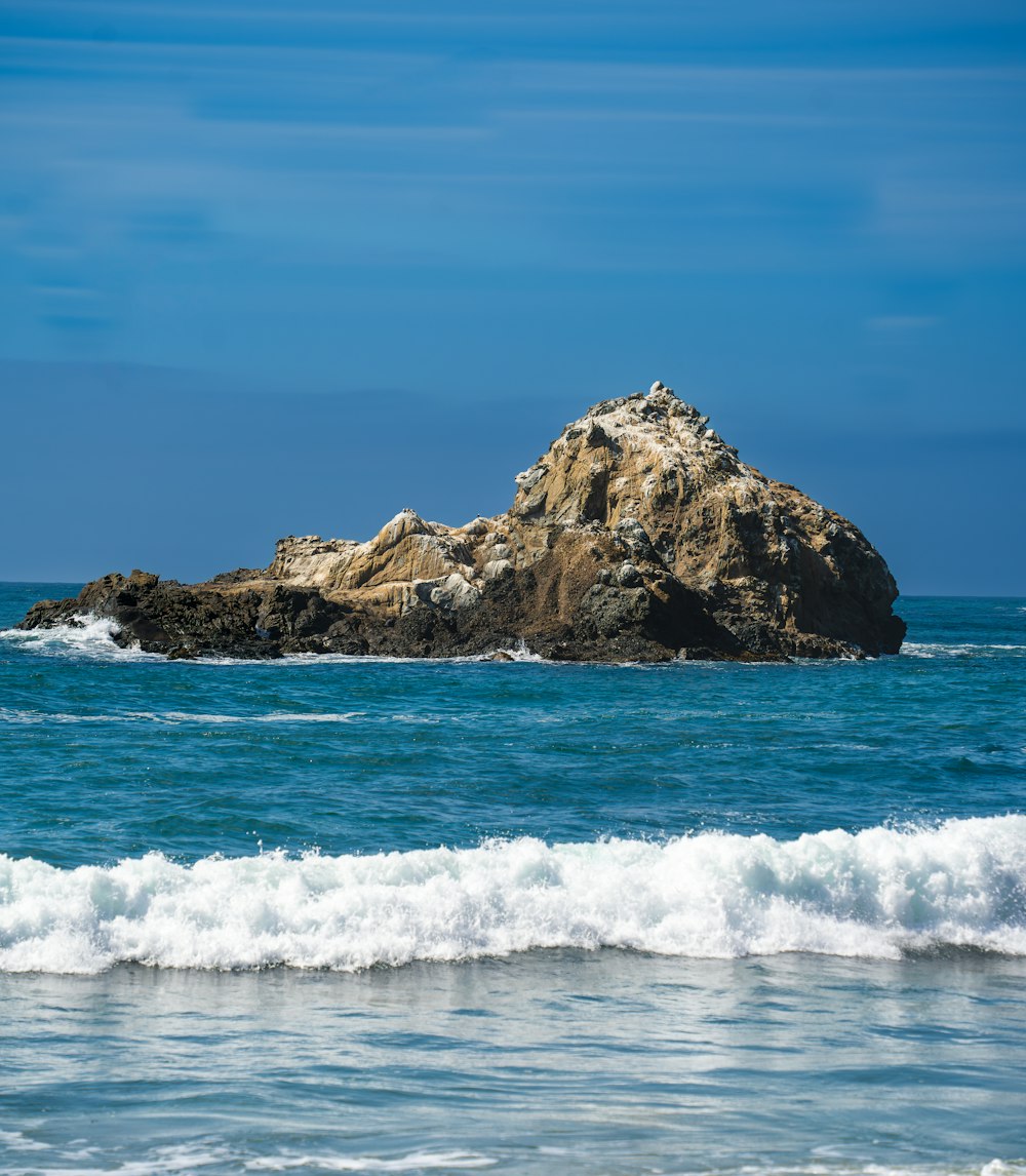 a large rock in the middle of the ocean