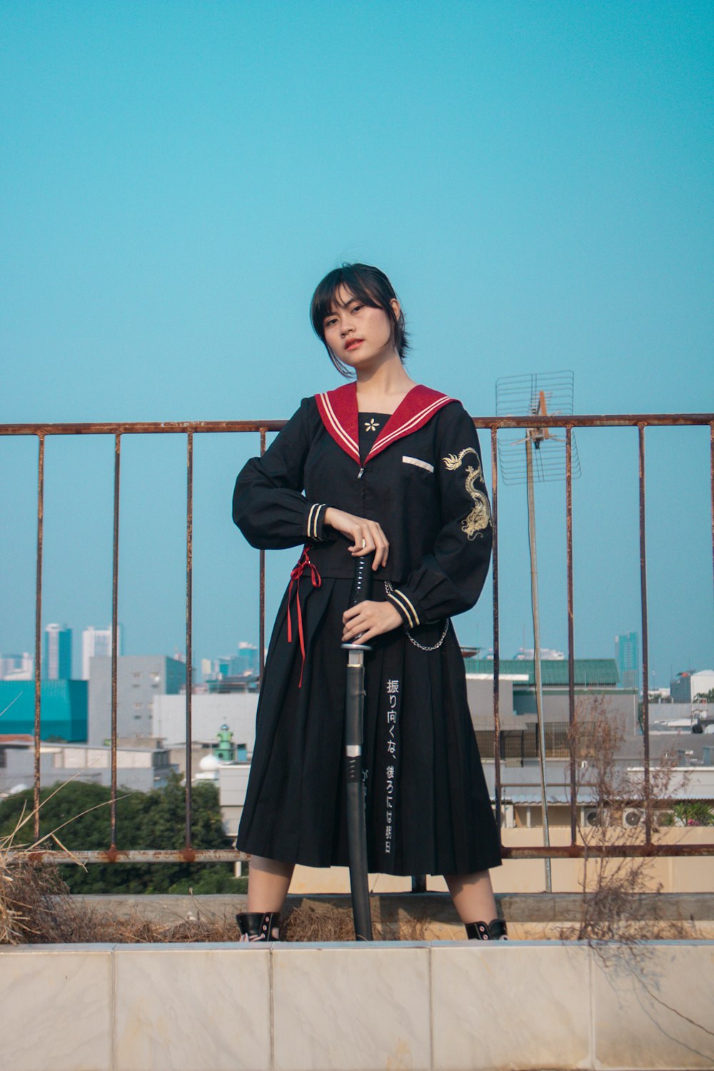 a woman in a black dress holding a baseball bat