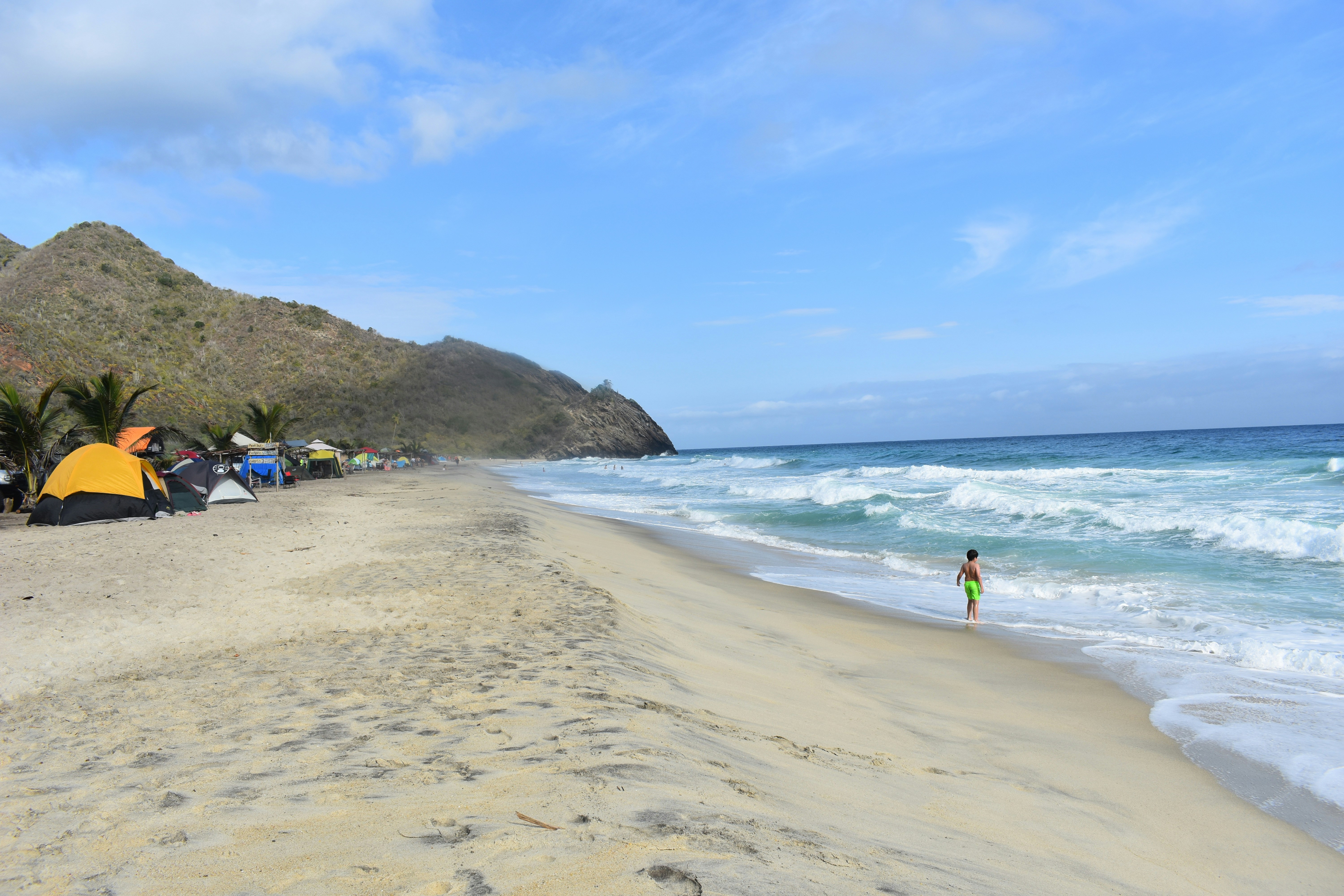 a person standing on a beach next to the ocean