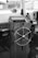 A vintage-looking ship's helm station with a wooden steering wheel and gauges. The interior has a rustic feel and includes communication equipment like a radio.