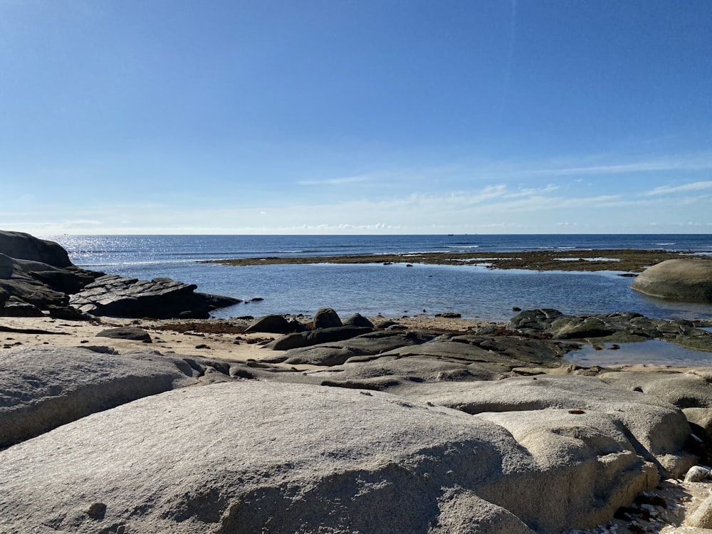 a view of a body of water from a rocky shore