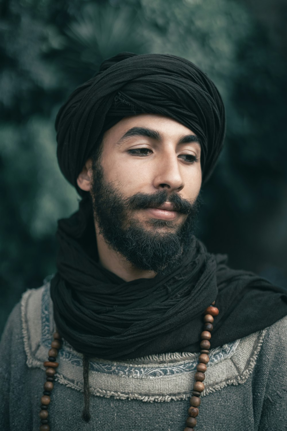 a man with a beard wearing a black turban