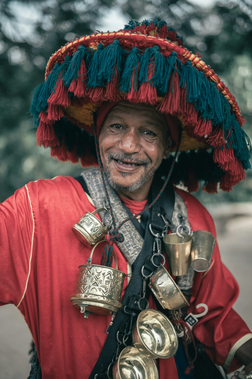 a man wearing a hat with bells around his neck