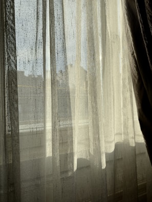 Sheer curtains softly diffusing natural light in a bright kitchen.