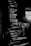 Lines of computer code are displayed on a screen in a dark setting, with a faint reflection of a person taking a picture in the background.