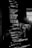 Lines of computer code are displayed on a screen in a dark setting, with a faint reflection of a person taking a picture in the background.