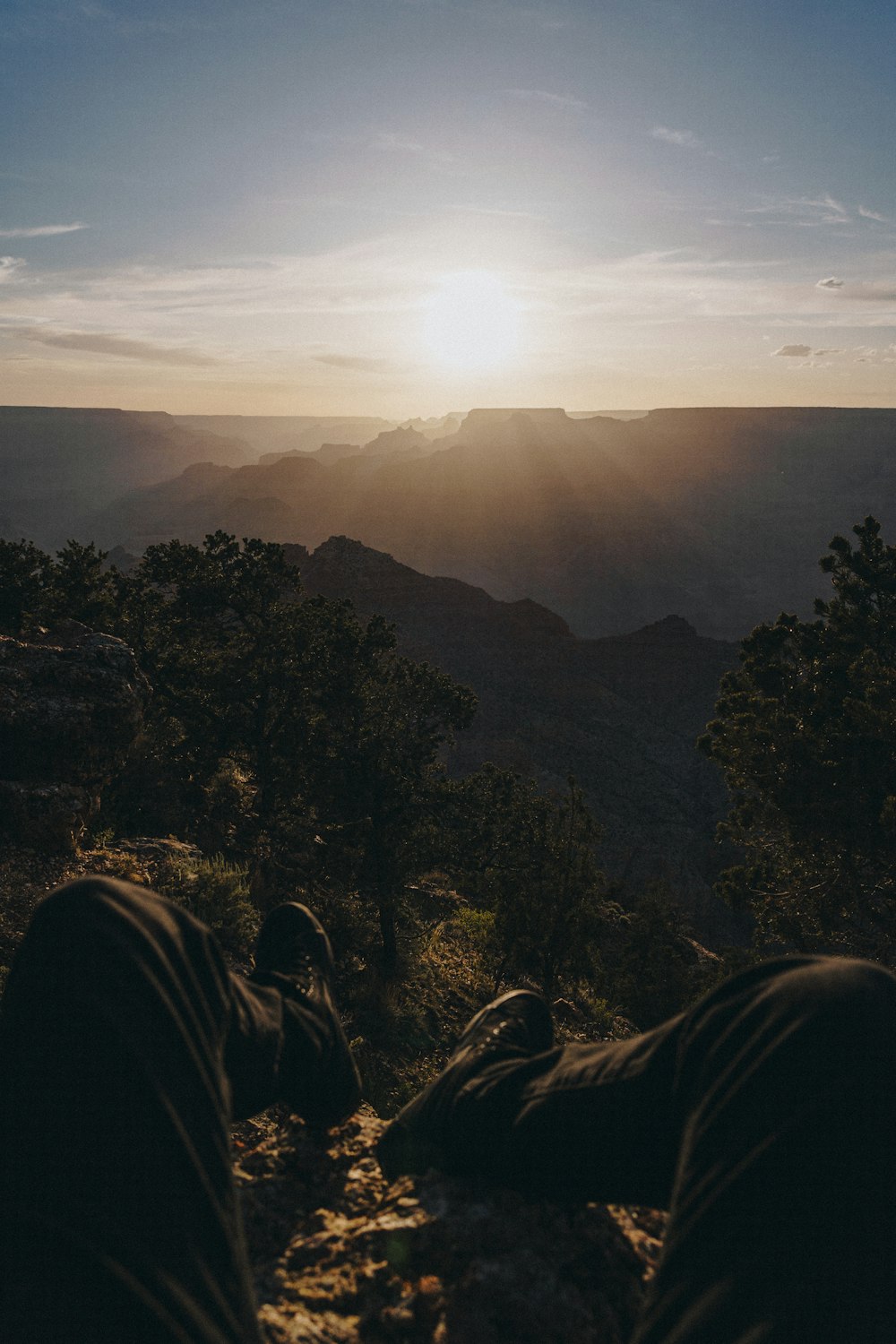 a person laying on the ground with the sun in the background