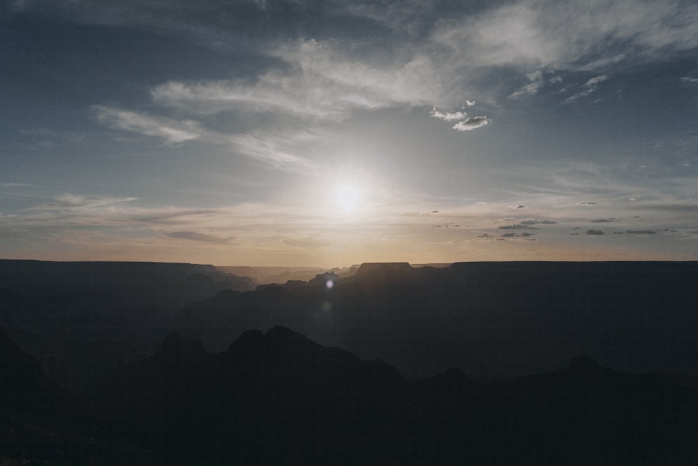 the sun is setting over a mountain range