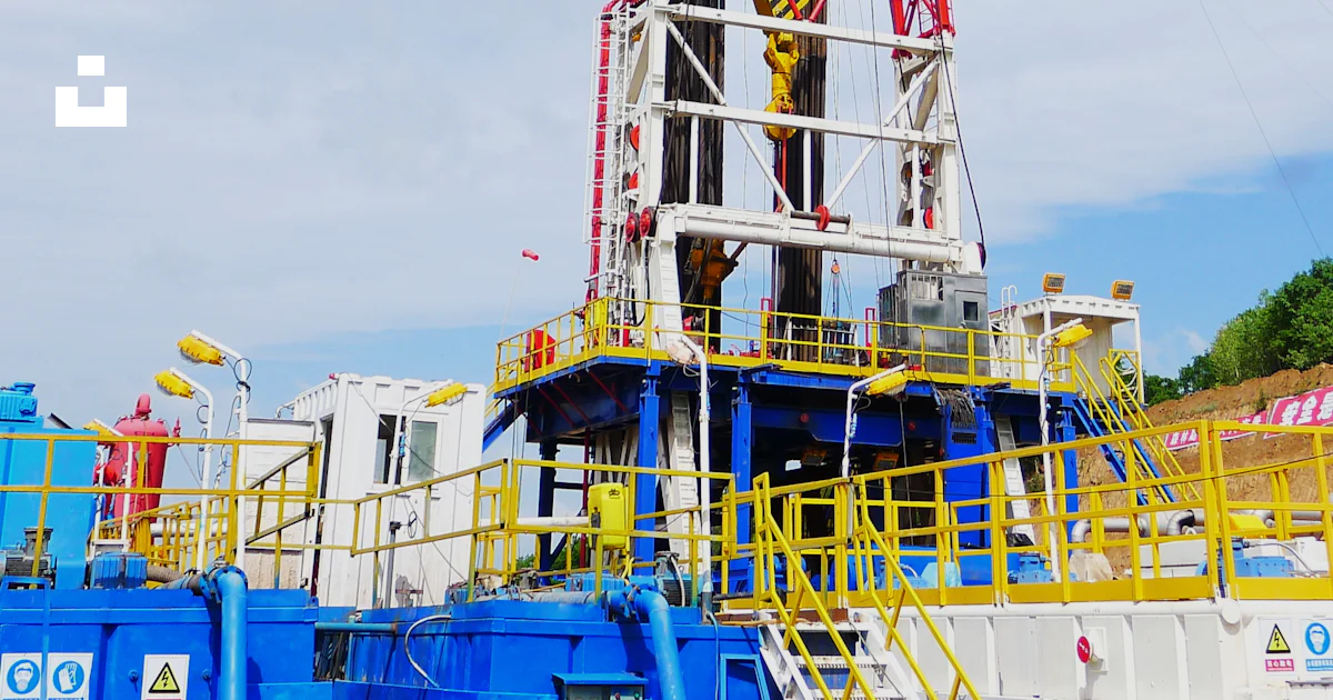 Oil Rig Red A red and white drilling rig sitting on top of a field photo – Free 井架 ...