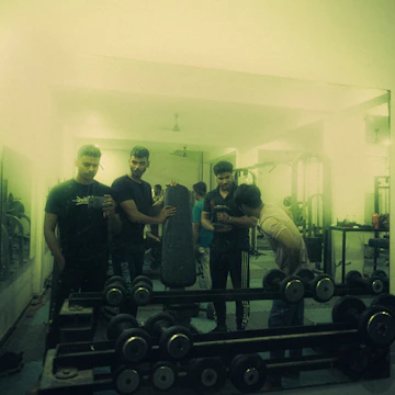 A group of diverse students learning strength training techniques using various gym machines.