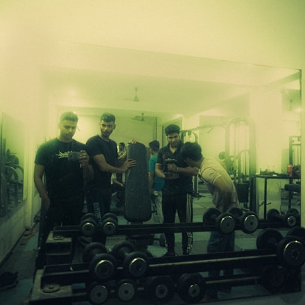 A group of athletes training with weights in a bright gym environment.