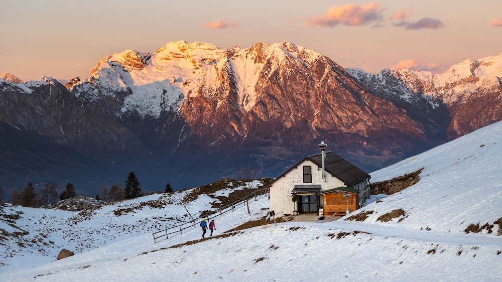 a small white house in the middle of a snowy mountain