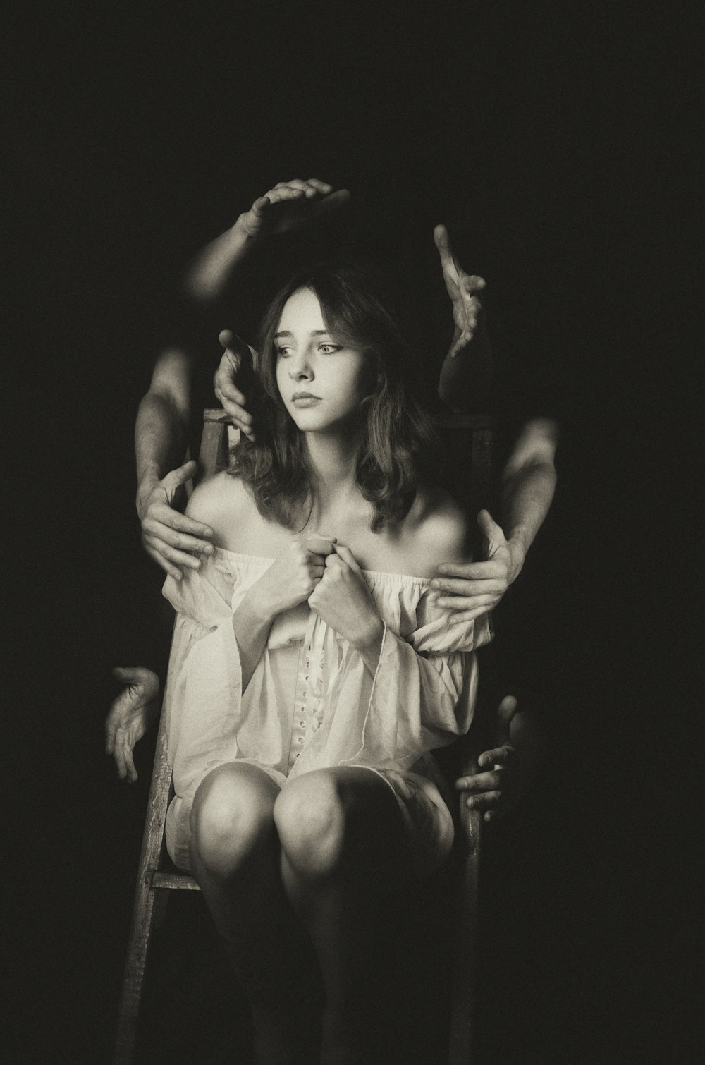 a black and white photo of a woman sitting in a chair