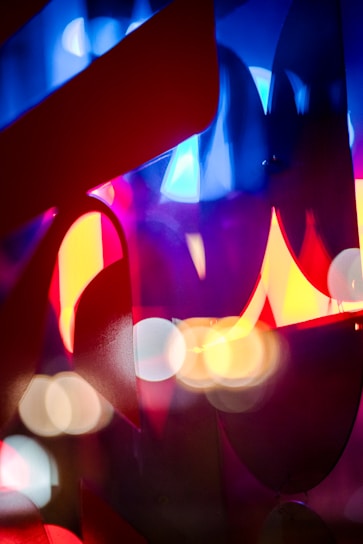 Abstract shapes and light bokeh in vibrant colors like blue, red, and yellow create a dynamic and energetic composition.