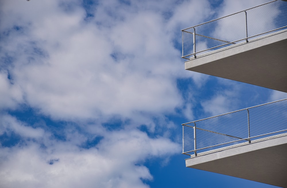 a building with a balcony and balconies against a cloudy blue sky