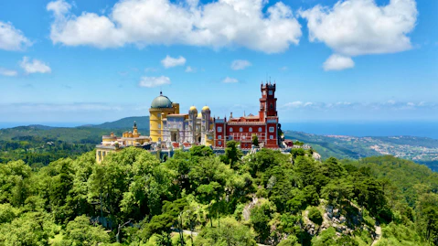 a large building on top of a lush green hillside