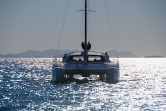 a sailboat in the water with mountains in the background