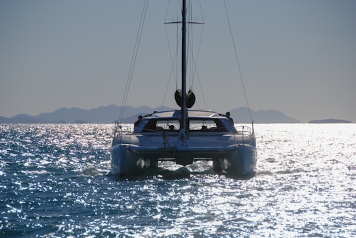 a sailboat in the water with mountains in the background