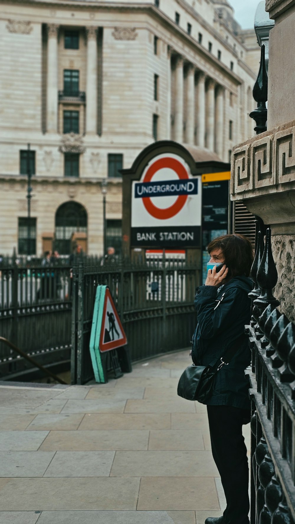 a woman standing on a sidewalk talking on a cell phone