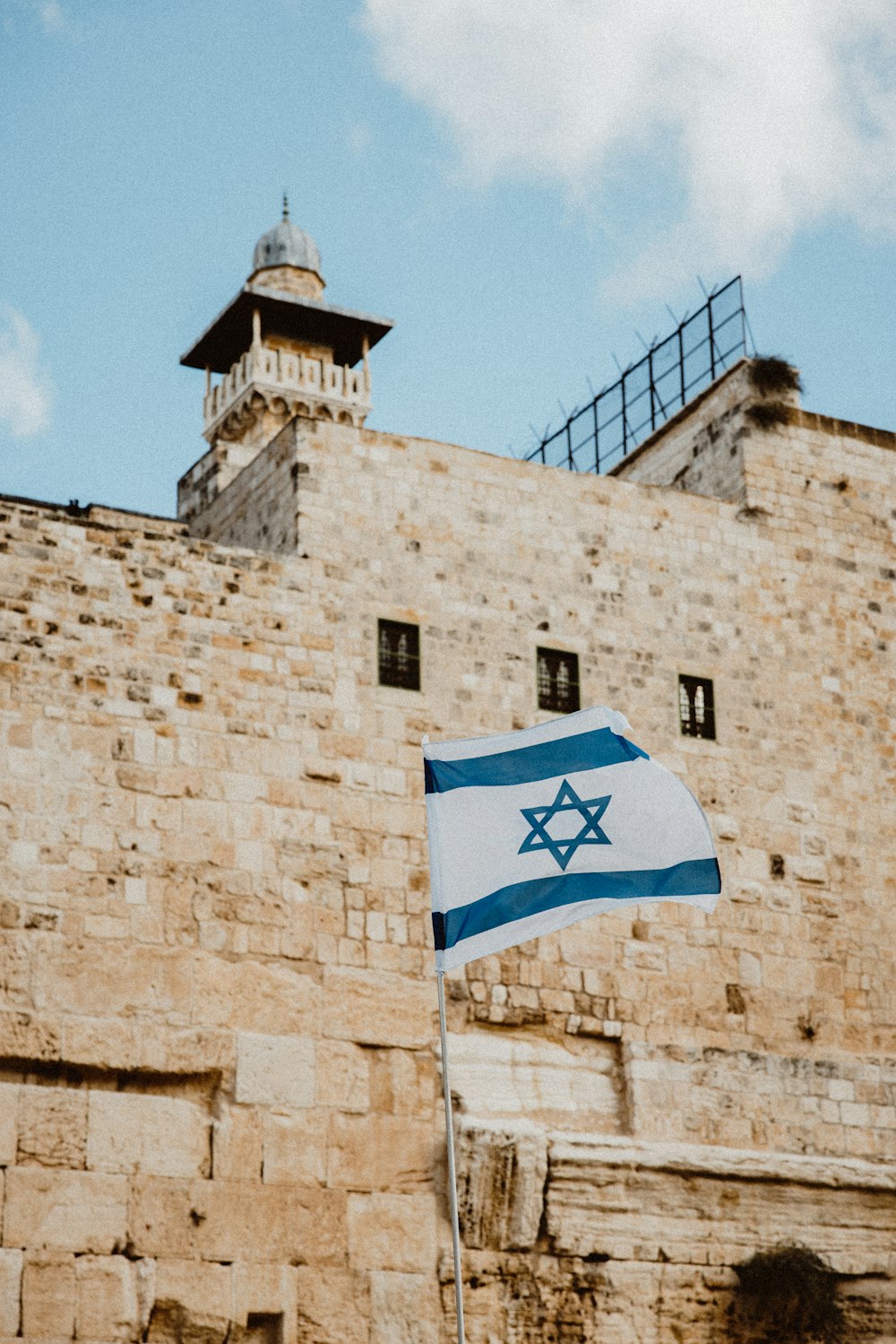 a flag flying in front of a stone building