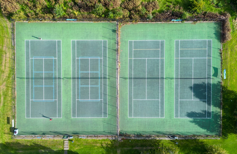 an aerial view of two tennis courts in a park