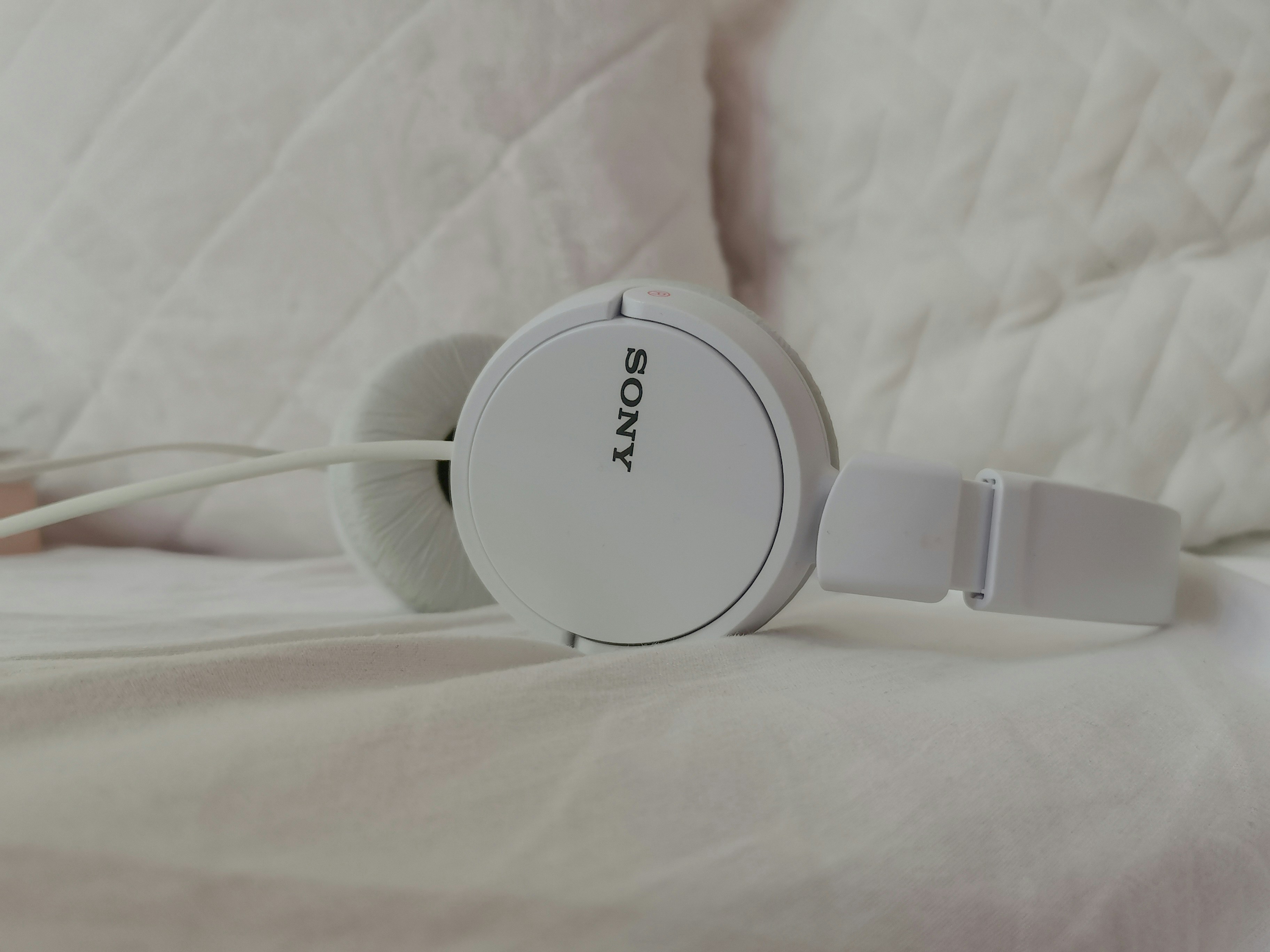 a pair of headphones sitting on top of a bed
