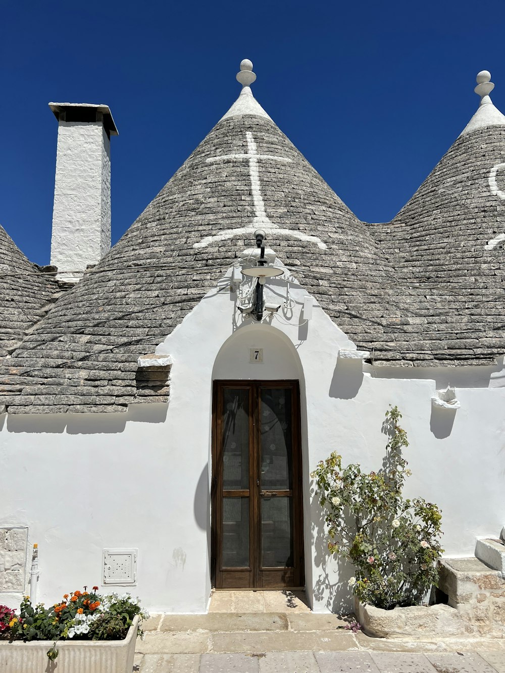 a white building with three chimneys and a door