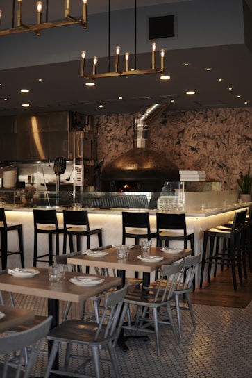 Cozy restaurant interior with wood-fired oven and sizzling grill in the background