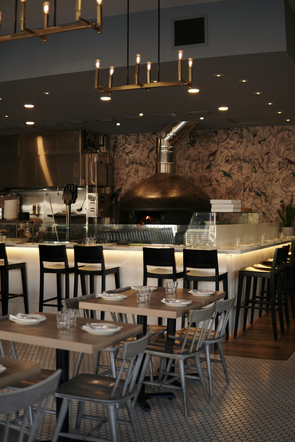 a restaurant with tables and chairs in front of an oven