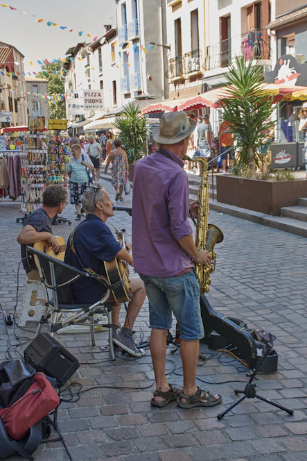 A lively street scene with a small acoustic band playing outdoors as a diverse crowd listens and enjoys the music.