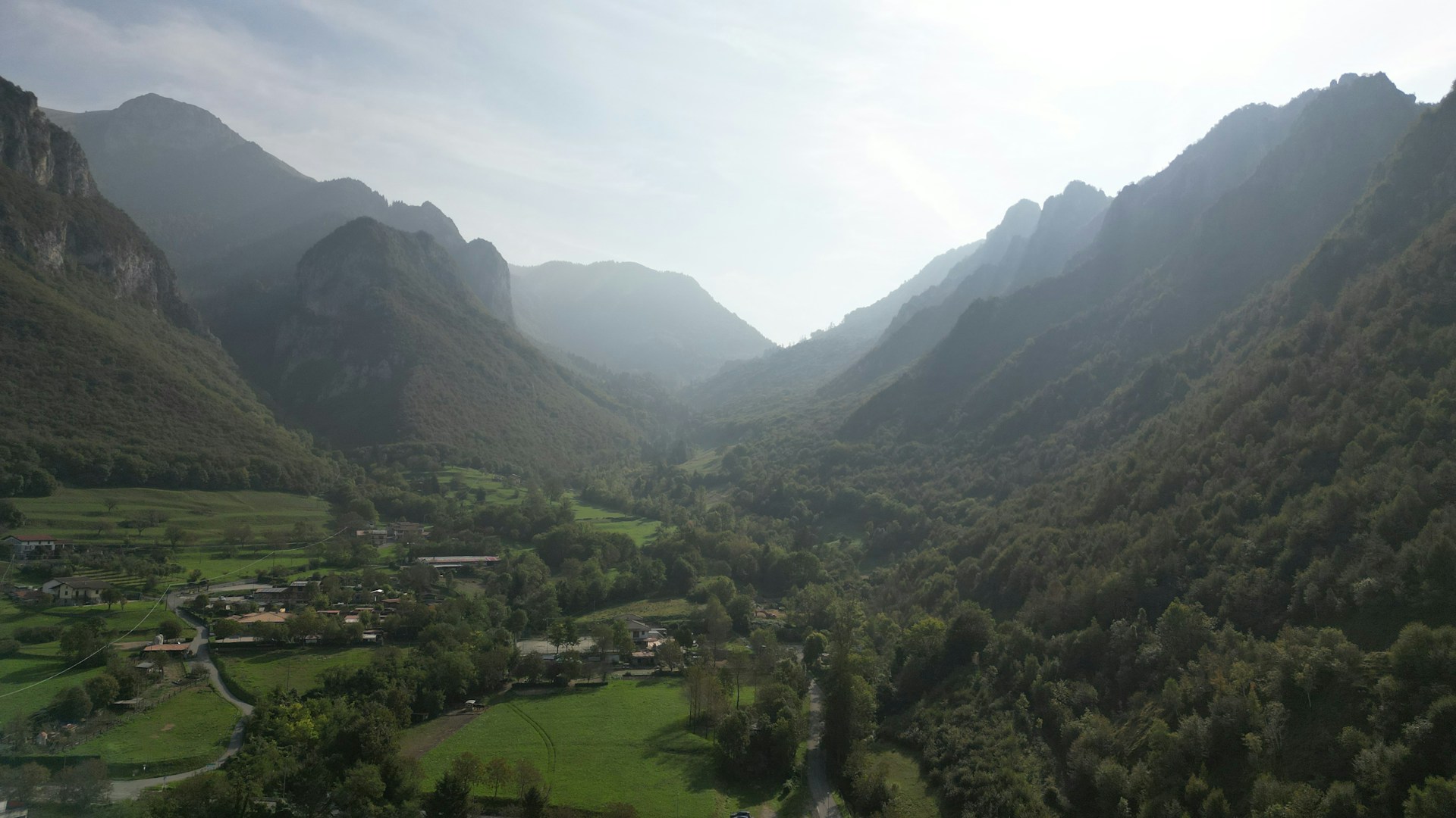 A serene mountain valley in northern Pakistan bathed in golden sunlight, with a family enjoying a picnic surrounded by lush greenery.