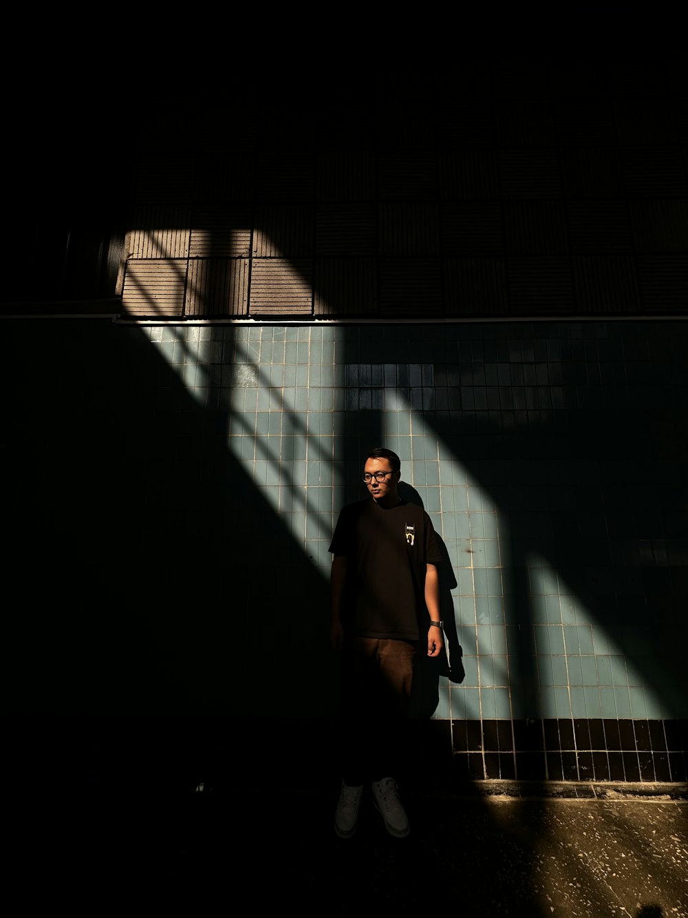 a man standing in the shadows of a building