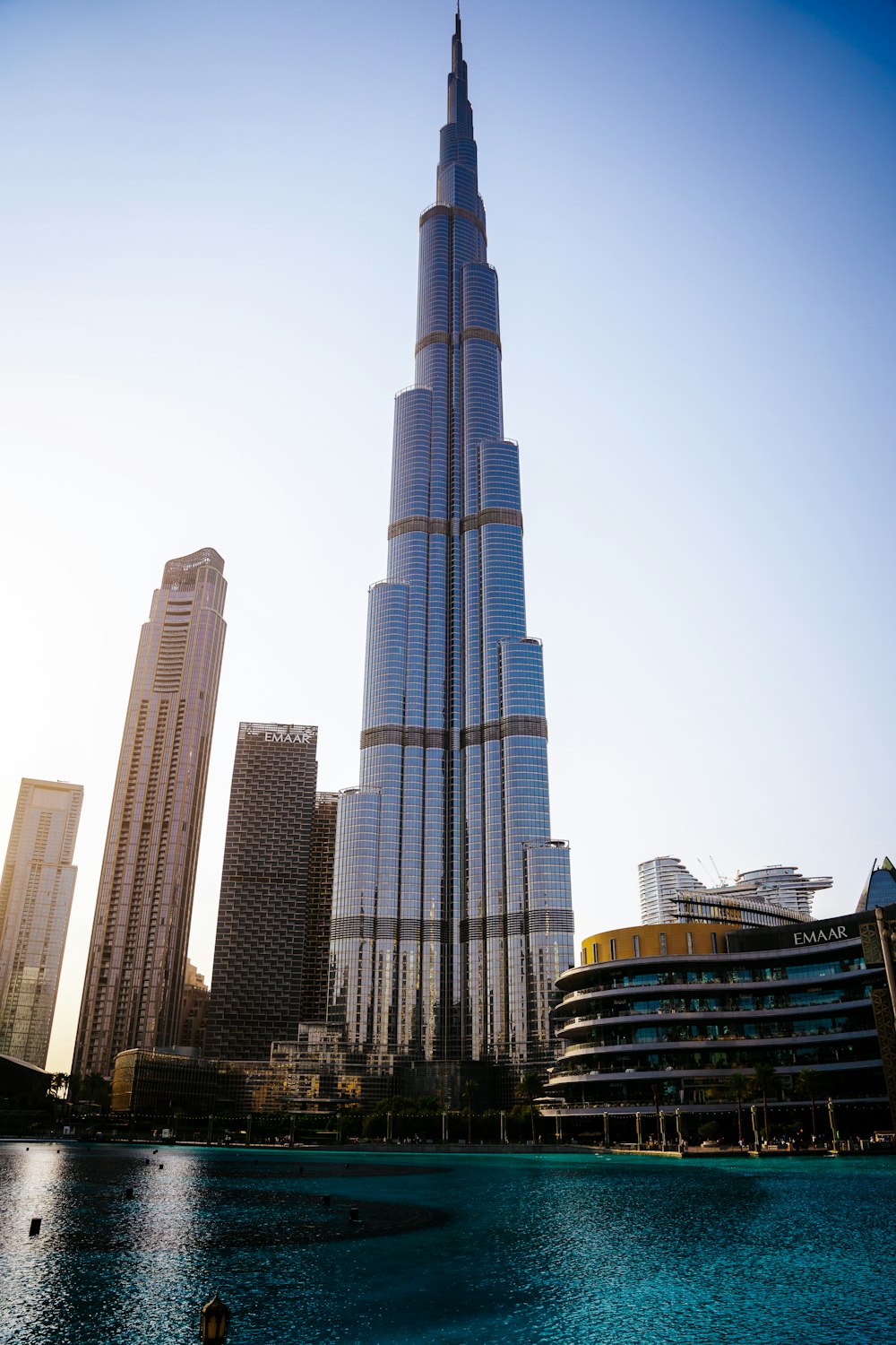 a tall building towering over a city next to a body of water