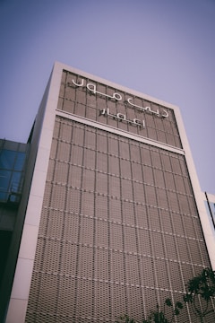 A modern commercial building in Ajman Free Zone under clear blue sky.