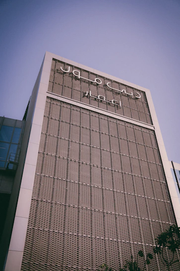 High-resolution photo of Alfares Trading FZC's office building facade in Ajman under clear blue sky.