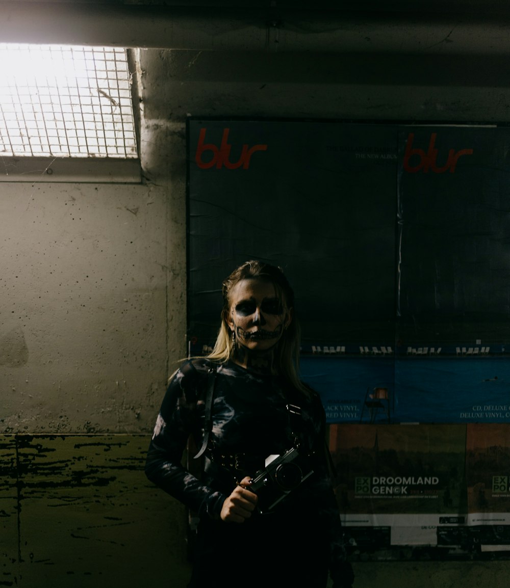 a woman in a black outfit holding a gun