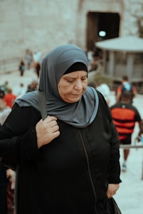 a woman in a hijab standing in front of a crowd of people