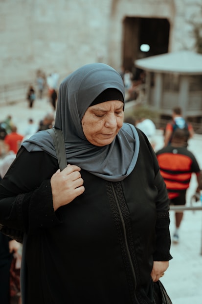 a woman in a hijab standing in front of a crowd of people