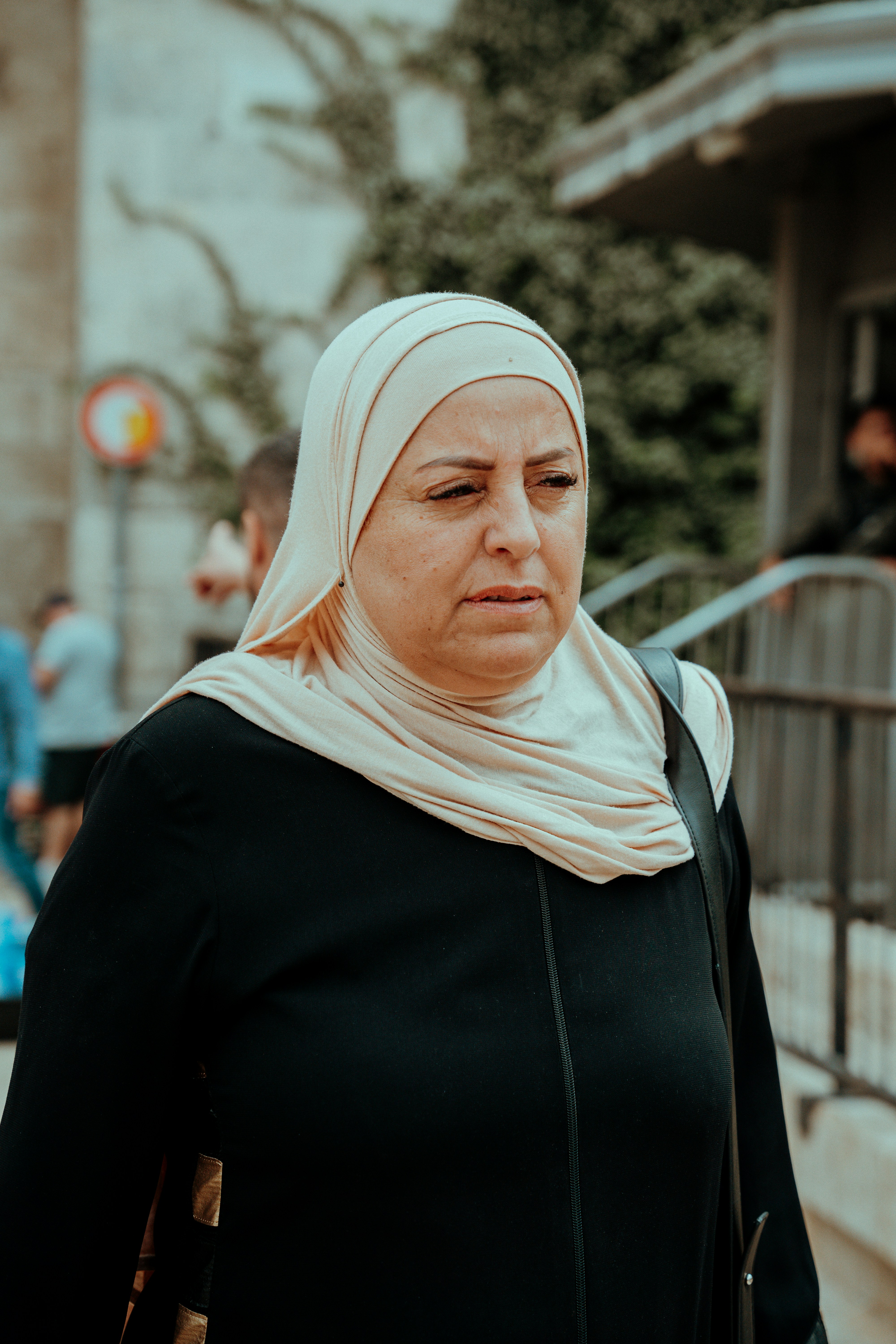 a woman wearing a headscarf walking down a street