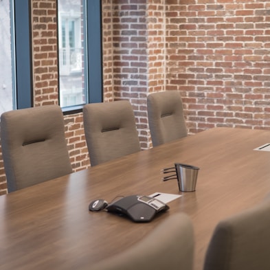a conference room with a wooden table and chairs by Jonathan Wells (@thedigstudios)