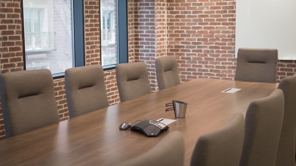 una sala conferenze con tavolo e sedie in legno