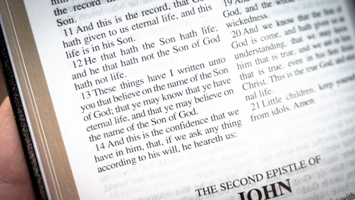 Hands holding a Bible open to Ephesians 6, the armor of God passage.