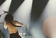 a man standing on a stage with a guitar