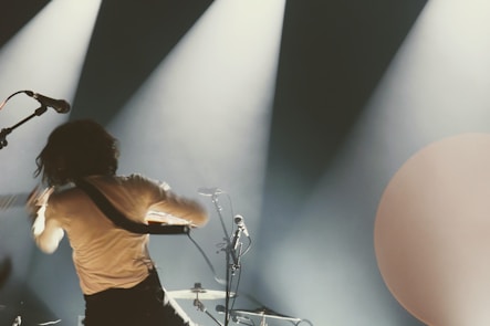 a man standing on a stage with a guitar