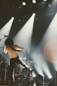 a man standing on a stage with a guitar