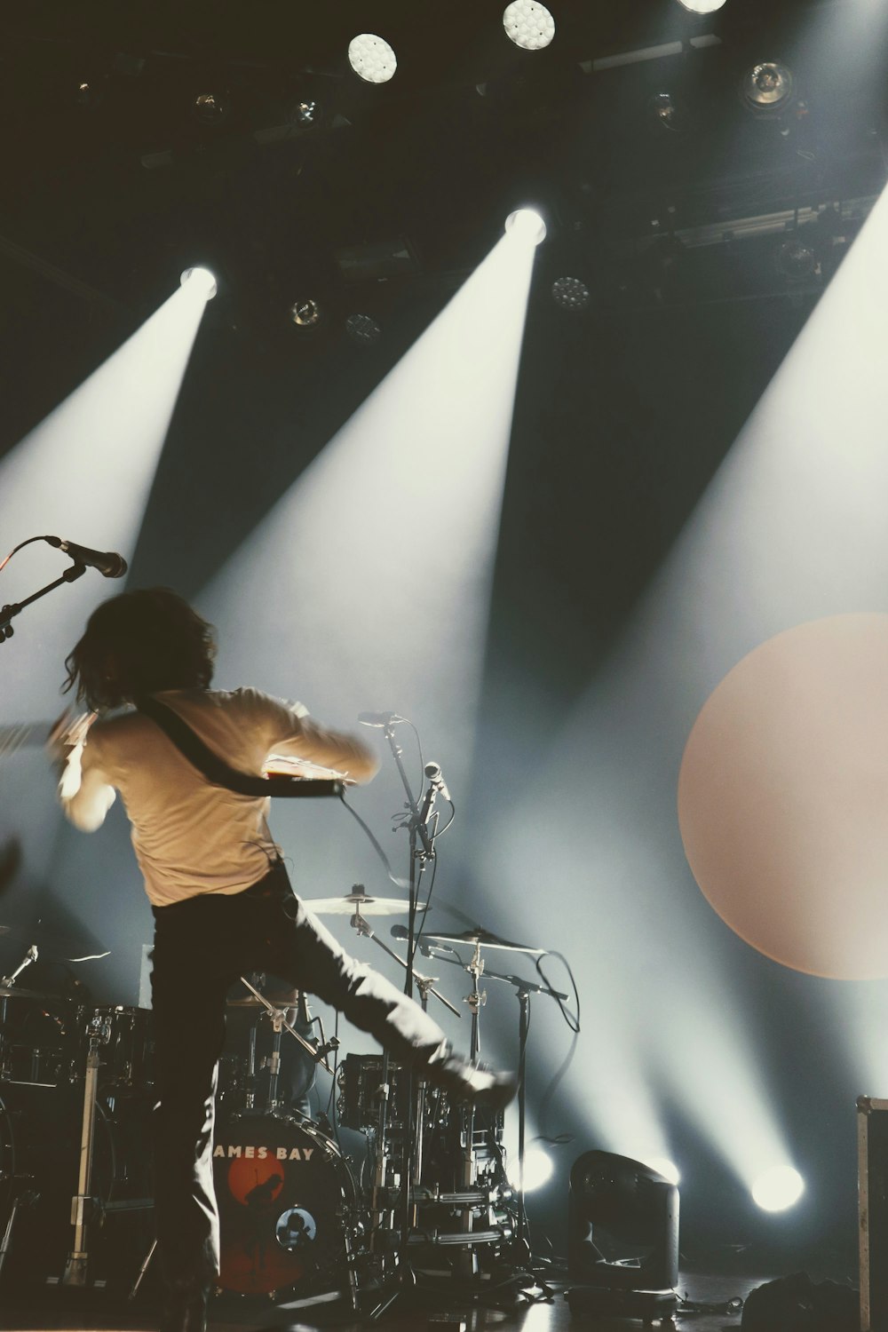 a man standing on a stage with a guitar