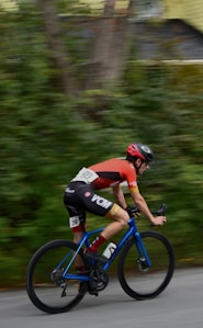 a man riding a blue bike down a street