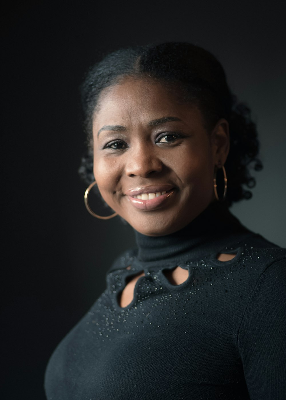 a woman in a black top smiling at the camera