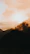 A confident woman standing tall on a mountain peak at sunrise.