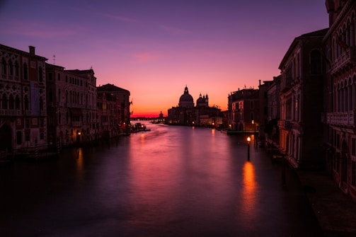 A serene view of Amsterdam’s canal lined with historic narrow houses under a soft sunset.
